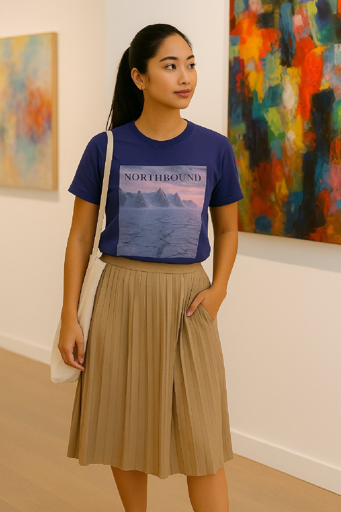 Woman wearing a blue t-shirt with 'Northbound' design in an art gallery.
