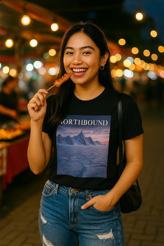 Woman wearing a black t-shirt with a mountain graphic and 'Northbound' text, standing in a night-time outdoor setting.