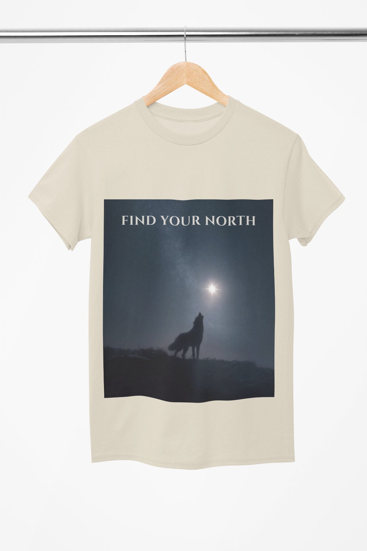 T-shirt with a graphic of a wolf howling at the moon and 'Find Your North' text, hanging on a wooden hanger.