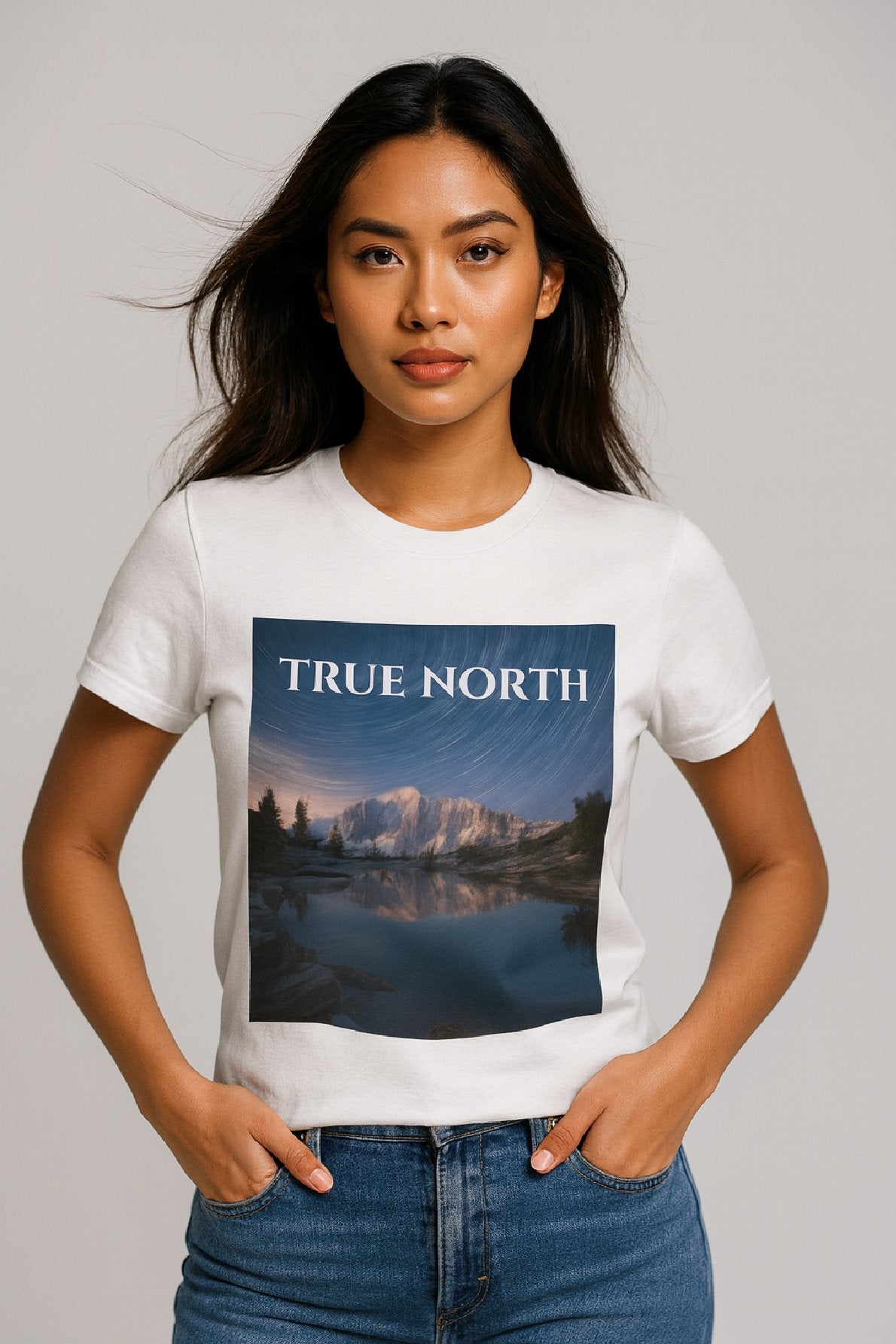 Person wearing a white t-shirt with a mountain graphic and 'True North' text.