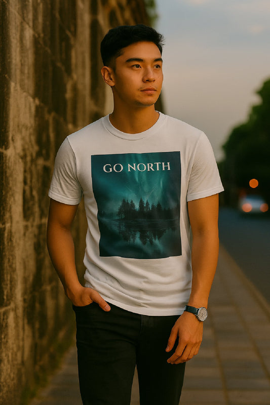 Man wearing a t-shirt with 'Go North' graphic design standing against a stone wall.
